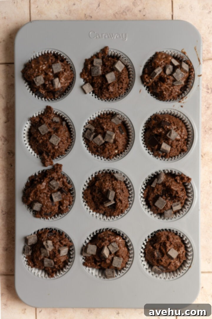 Ultimate Bakery Triple Chocolate Muffins 8 Chocolate muffin batter in a muffin tin.