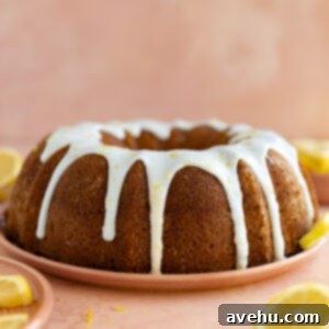 Glazed lemon bundt cake on a pink plate, ready to be served.