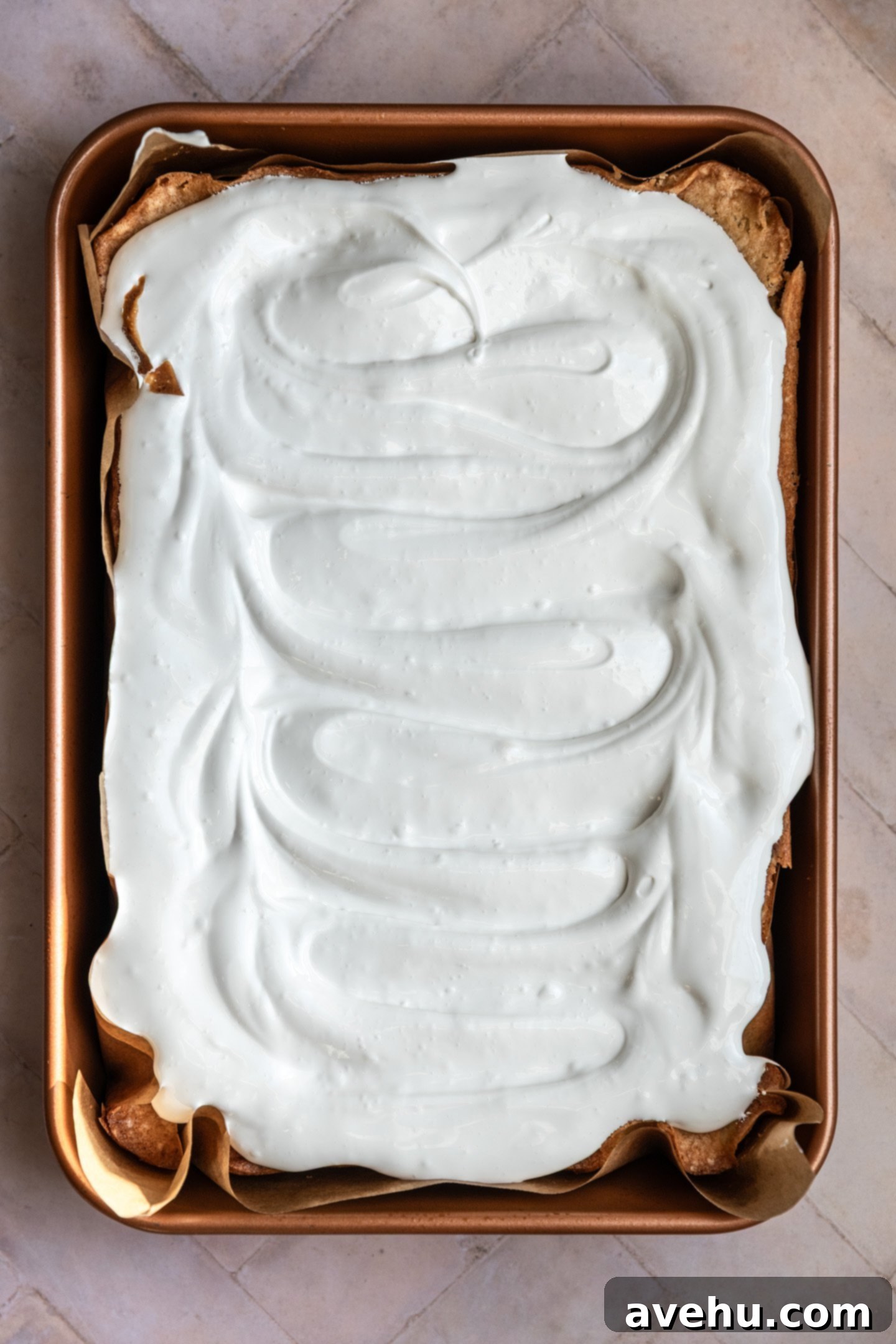 Effortless 7-Minute Frosting 2 7 minute frosting spread over a vanilla sheet cake, showcasing its fluffy texture.