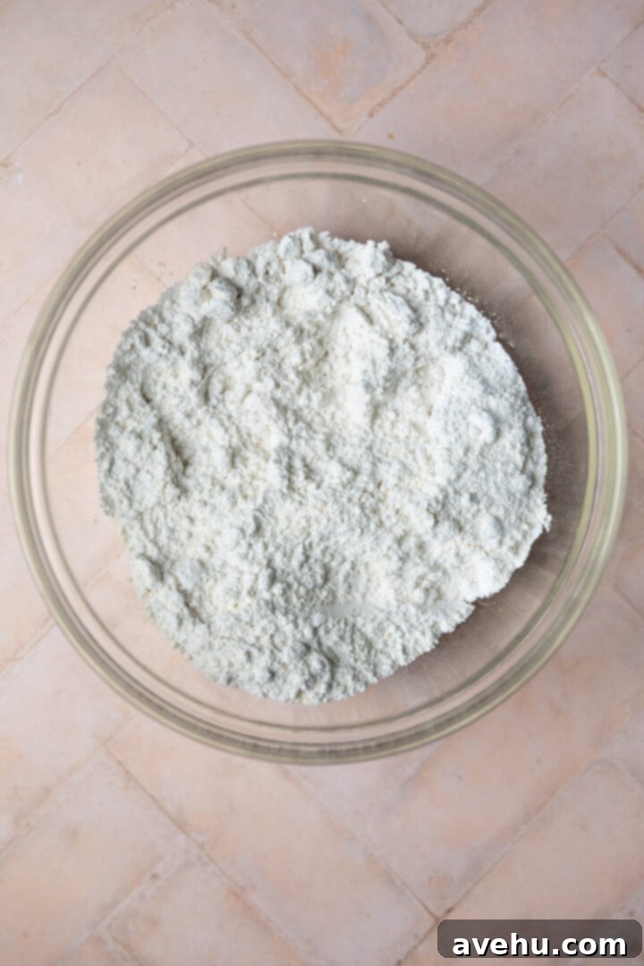 The Ultimate Vanilla Sheet Cake 5 Dry ingredients for a cake in a glass bowl.