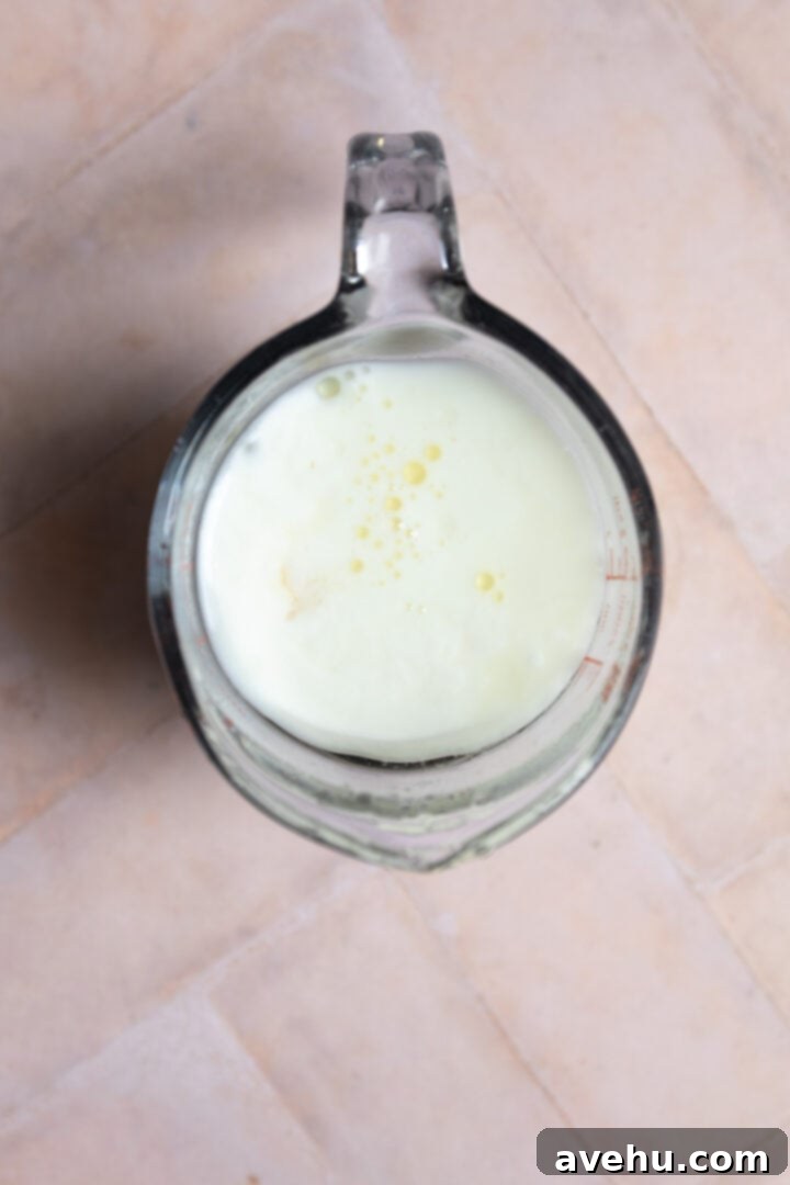 The Ultimate Vanilla Sheet Cake 6 Wet ingredients in a measuring cup.