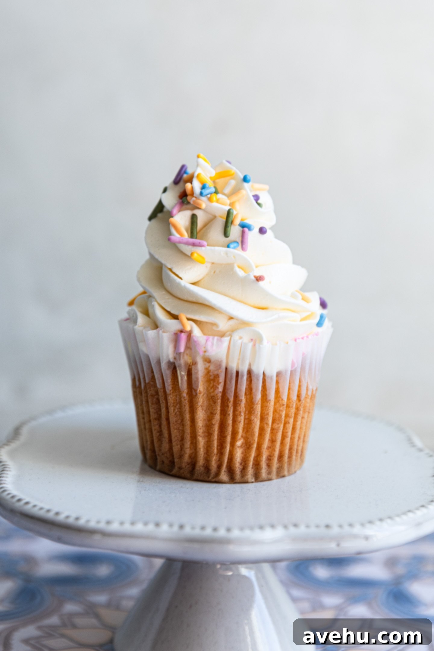 Seriously Addictive Swiss Meringue Buttercream 2 A vanilla cupcake piped with swiss meringue buttercream and colorful sprinkles.