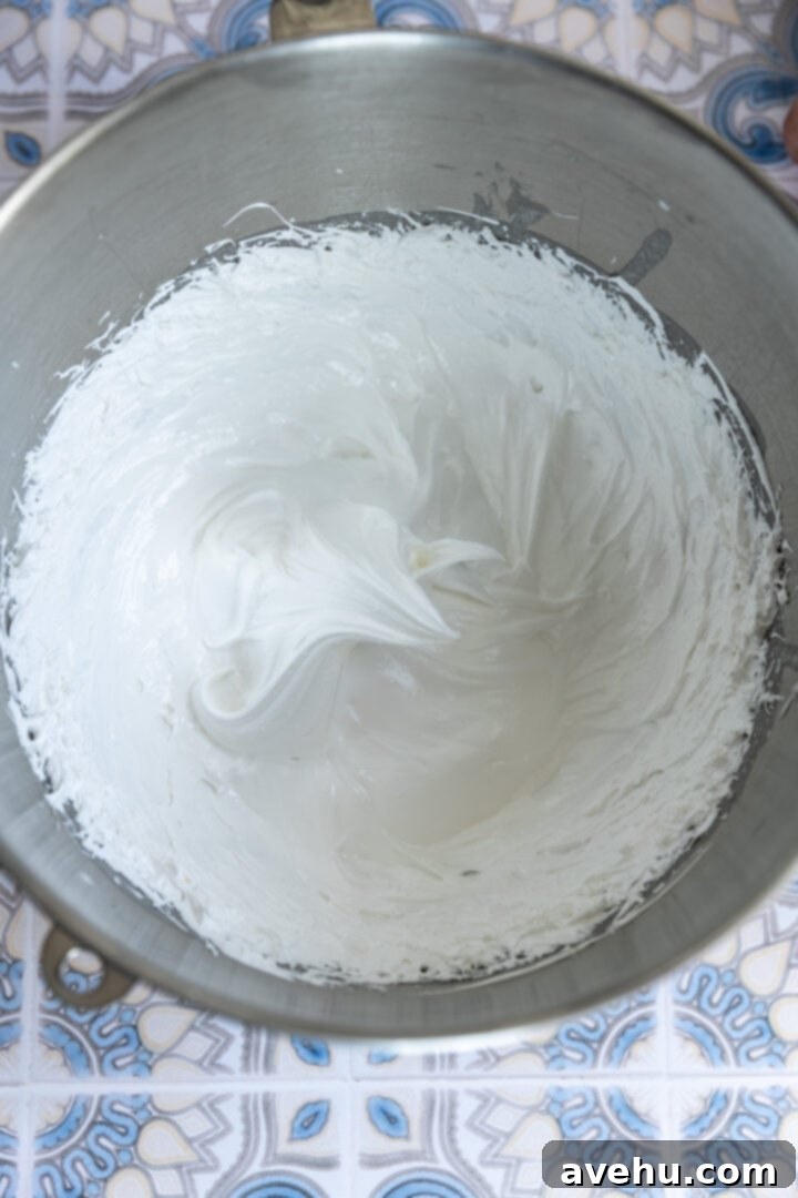 Seriously Addictive Swiss Meringue Buttercream 14 Stiff peaks on a meringue in a bowl.