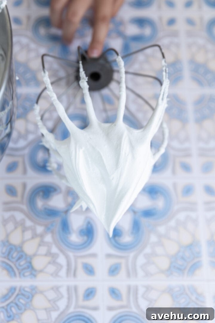 Seriously Addictive Swiss Meringue Buttercream 15 A beater with stiff peaks of meringue.