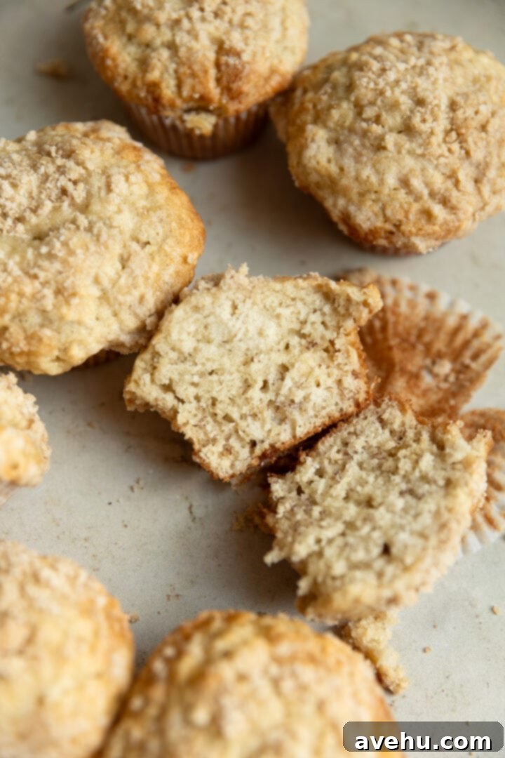 Perfectly Moist Bakery-Style Banana Muffins 9 A perfectly baked banana muffin split in half, revealing its incredibly fluffy and moist interior texture.