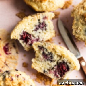 Crave-Worthy Blackberry Streusel Muffins 13 A perfectly baked blackberry streusel muffin, cut in half to reveal juicy blackberries within.