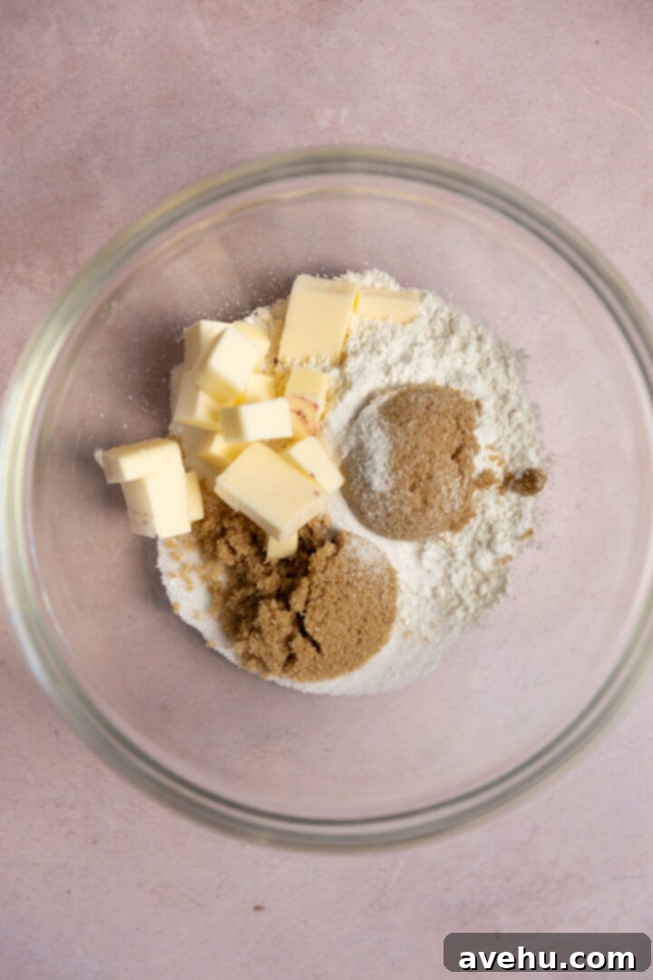 Crave-Worthy Blackberry Streusel Muffins 3 Ingredients for a buttery streusel topping in a glass bowl: flour, brown sugar, white sugar, and diced cold butter.