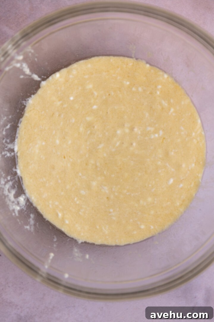 Crave-Worthy Blackberry Streusel Muffins 7 Wet ingredients for blackberry streusel muffins in a glass bowl: melted butter, oil, milk, yogurt, eggs, and vanilla extract.