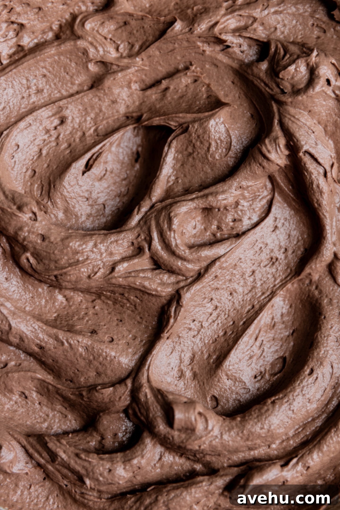 Decadent Cocoa Swiss Meringue Buttercream 2 Chocolate Swiss meringue buttercream swirled elegantly in a mixing bowl, ready to be used for decorating cakes or cupcakes.