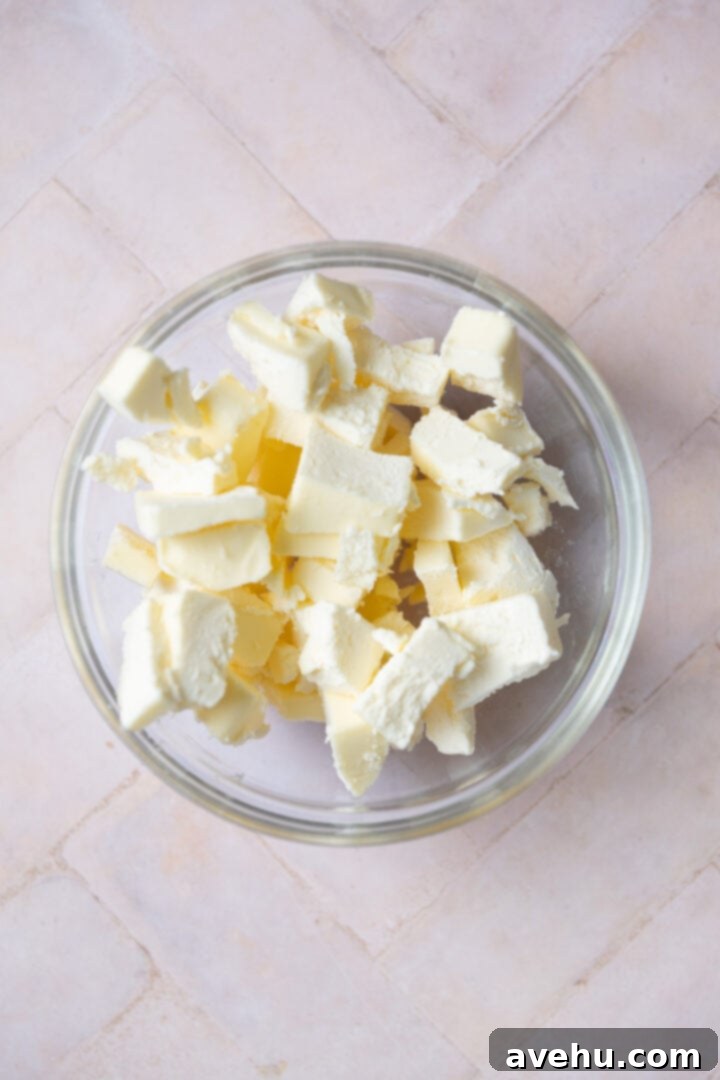 Decadent Cocoa Swiss Meringue Buttercream 6 Diced unsalted butter in a glass bowl, prepared and ready to be added to the meringue.