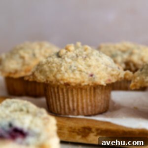 Ultimate Bakery Banana Blackberry Muffins 13 Blackberry banana muffin on a lined wooden cutting board.