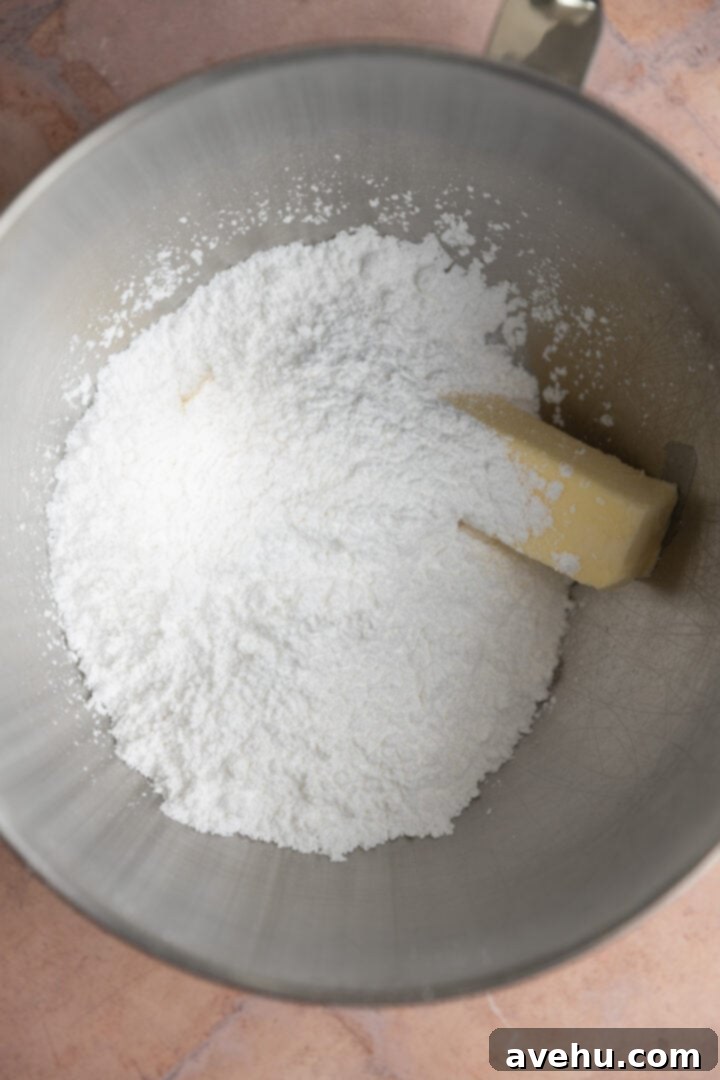 Lush 5-Minute Cookie Butter Frosting 3 Softened unsalted butter and powdered sugar are combined in a mixing bowl, ready for creaming.