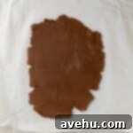 Zesty Orange Dark Chocolate Shortbread 5 Chocolate cookie dough evenly rolled out between two sheets of parchment paper.