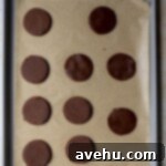 Zesty Orange Dark Chocolate Shortbread 6 Various chocolate cookie dough shapes cut out and arranged on a sheet tray before baking.