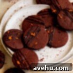 Zesty Orange Dark Chocolate Shortbread 7 Two white plates filled with garnished Dark Chocolate Orange Shortbread Cookies, ready to be served.