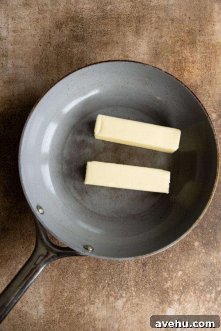 Your Ultimate Brown Butter Frosting 3 Two sticks of butter being added to a light-colored skillet, ready to melt for brown butter.