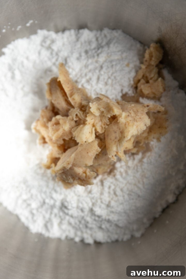 Your Ultimate Brown Butter Frosting 8 Softened brown butter added to a mixing bowl with powdered sugar, ready for creaming.