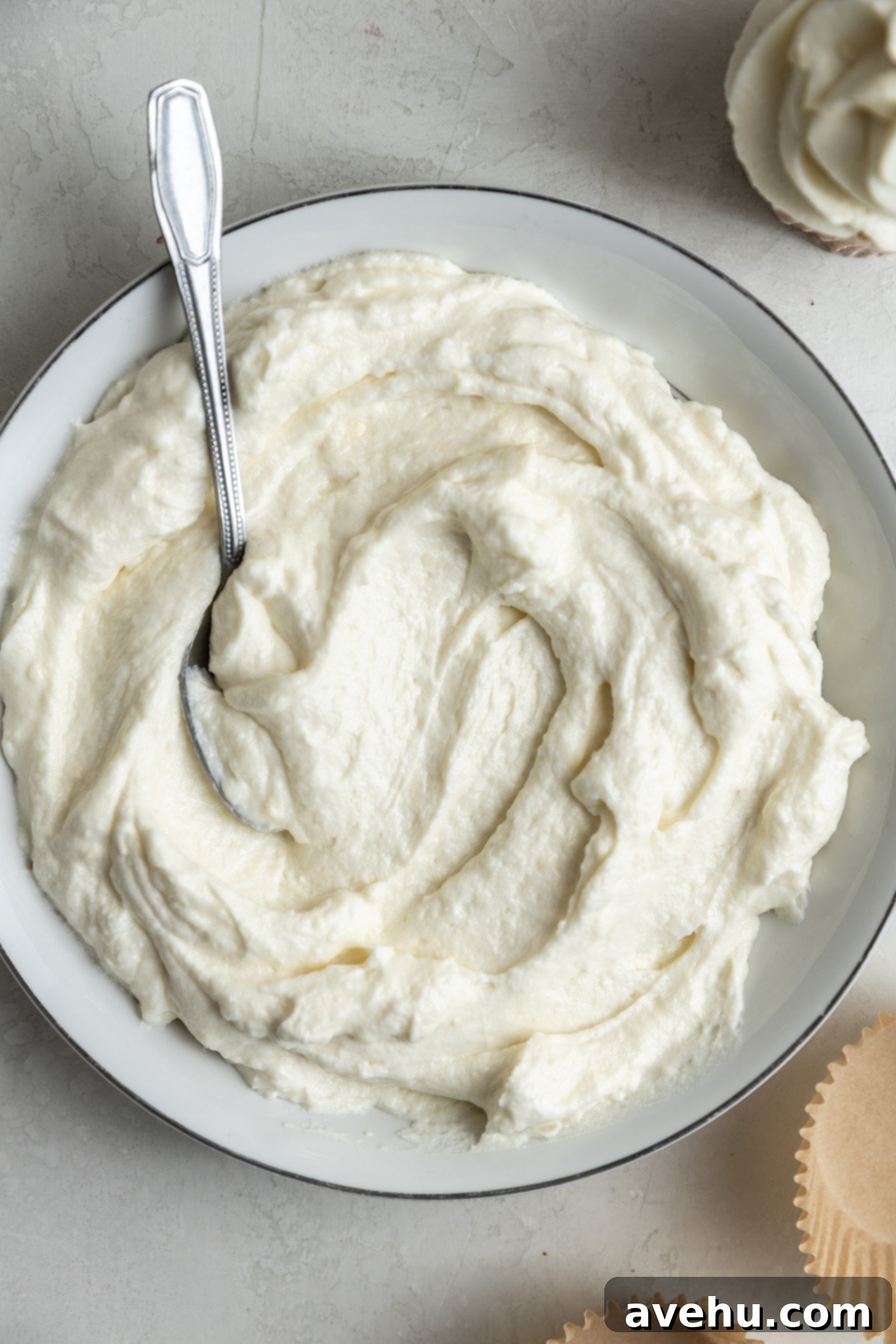 Effortless Cream Cheese Frosting No Powdered Sugar 3 Luscious homemade cream cheese frosting, crafted without powdered sugar, resting in a mixing bowl, ready for your desserts.