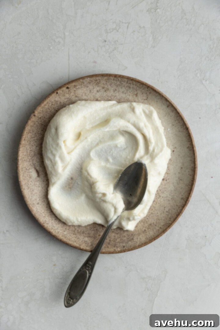 Effortless Cream Cheese Frosting No Powdered Sugar 6 A spoonful of the initial cream cheese frosting (without whipped cream) spread on a plate, highlighting its smooth, creamy consistency.