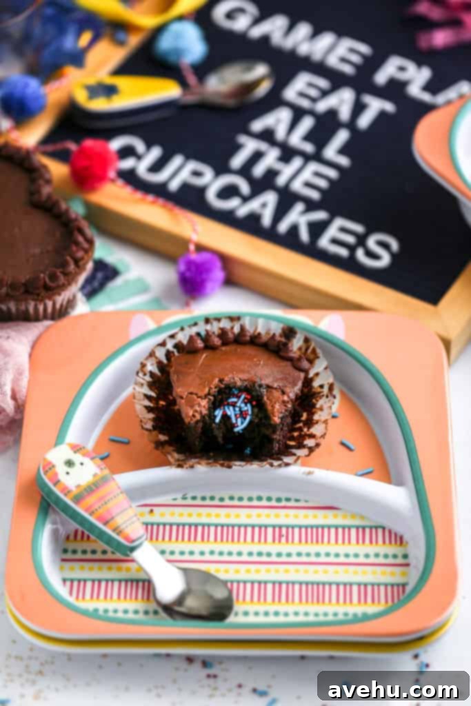 Game Day Pull Apart Football Cupcakes 9 A chocolate cupcake revealing a sprinkle surprise inside, served on a cheerful Skip Hop plate for a game day party.