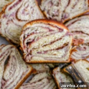 A slice of raspberry cheese babka lying on other slices of babka