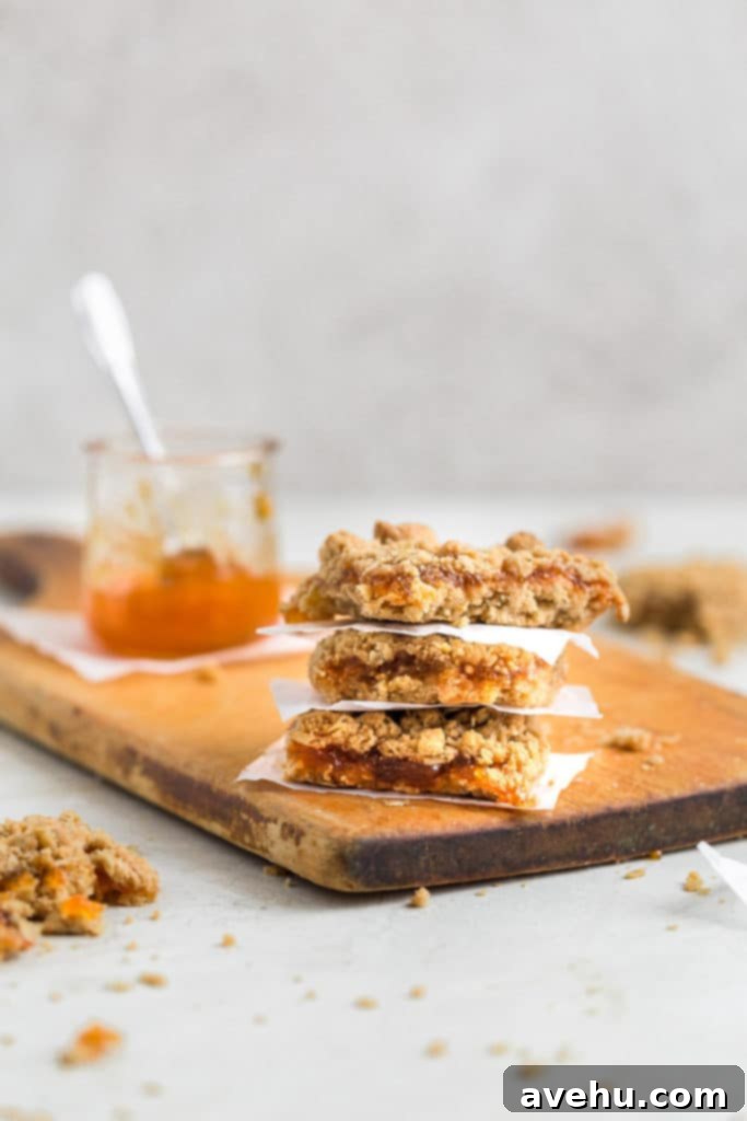 Golden Apricot Oat Crumble Bars 2 Apricot bars stacked on each other on a wooden cutting board