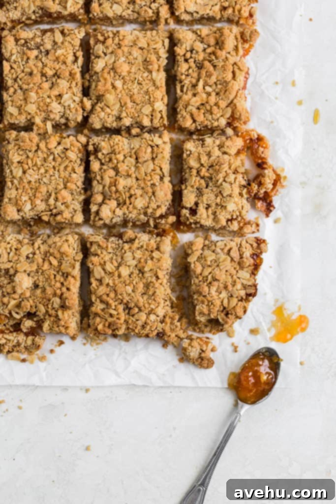 Golden Apricot Oat Crumble Bars 3 Apricot bars cut into 9 slices on a piece of parchment paper