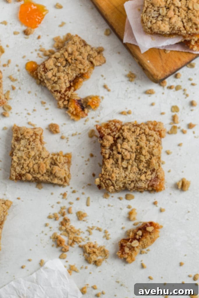 Golden Apricot Oat Crumble Bars 4 Apricot bars with bites in them on a gray surface