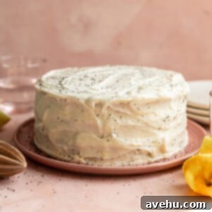 Sunshine Lemon Poppyseed Yogurt Layer Cake 15 A lemon poppy seed cake on a pink plate.