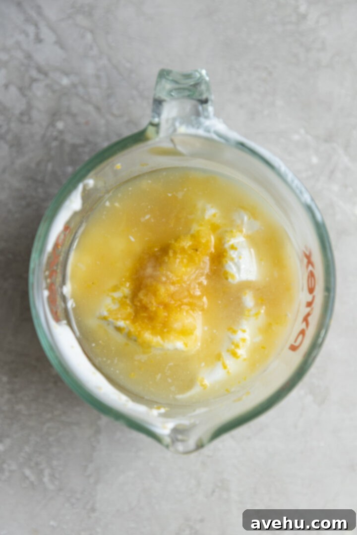 Sunshine Lemon Poppyseed Yogurt Layer Cake 5 Yogurt, fresh lemon juice, and lemon zest measured in a liquid measuring cup.