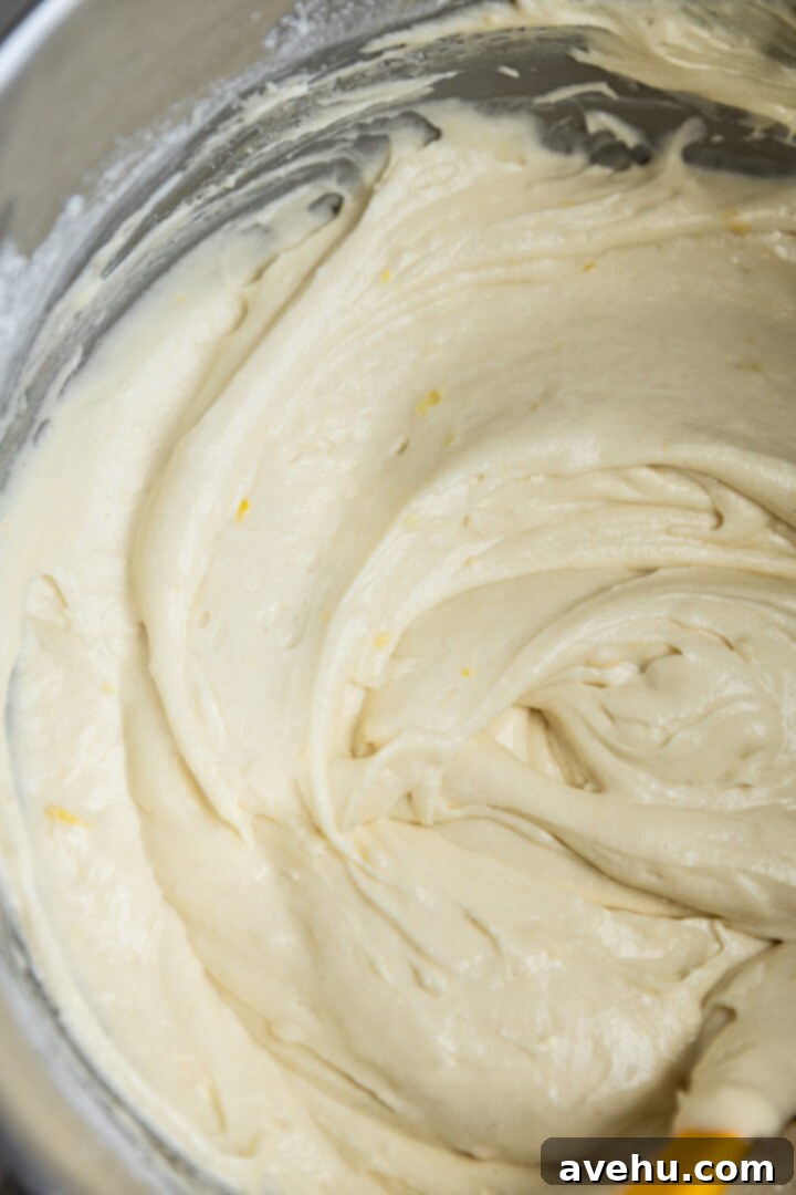 Sunshine Lemon Poppyseed Yogurt Layer Cake 6 Lemon cake batter in a mixing bowl, showcasing its smooth consistency.