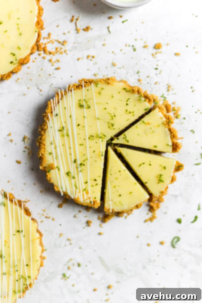 Foolproof Key Lime Pie 2 Three slices cut out of a mini key lime pie, showcasing its creamy filling and graham cracker crust.