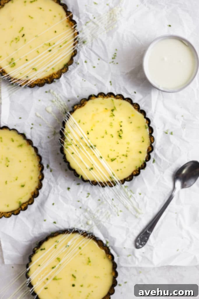 Foolproof Key Lime Pie 3 Mini key lime pies drizzled with white chocolate on a clean white background, ready to be served.