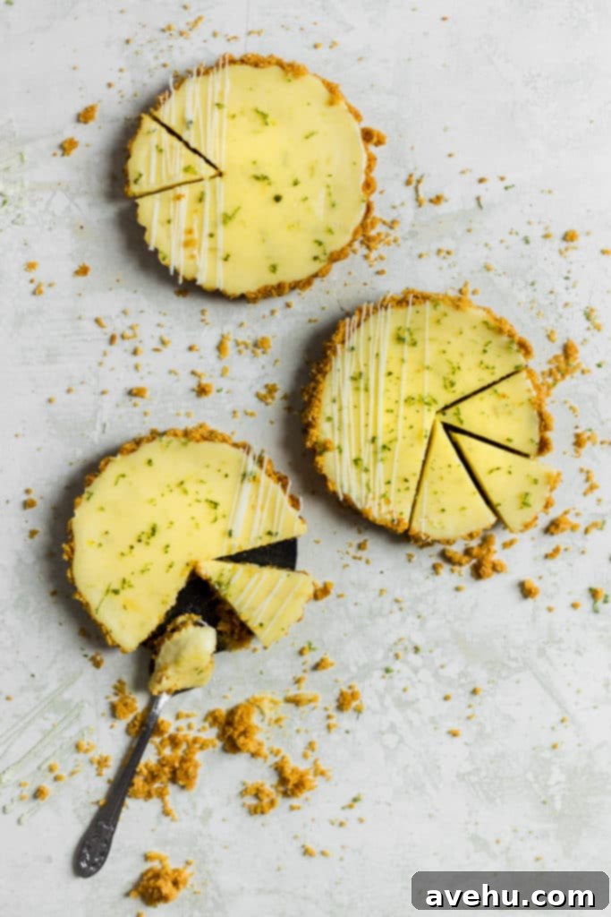 Foolproof Key Lime Pie 4 Several mini key lime pies with slices cut out, showing the thick, creamy filling and golden crust.