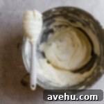 Effortless and Perfectly Moist Blackberry Cake 15 a mixing bowl filled with frosting with a spatula sitting on top of the bowl