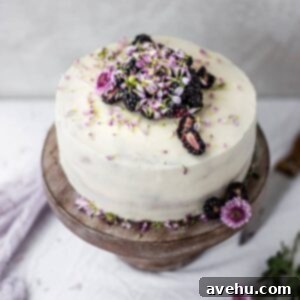 Effortless and Perfectly Moist Blackberry Cake 10 The top of a white cake with blackberries and flowers, a perfect homemade blackberry cake.
