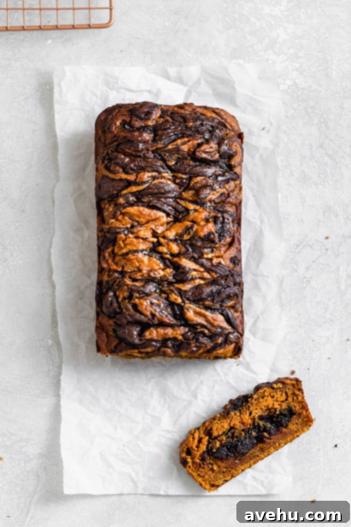 Decadent Chocolate Chip Pumpkin Bread 2 Chocolate swirled pumpkin bread on a white surface.
