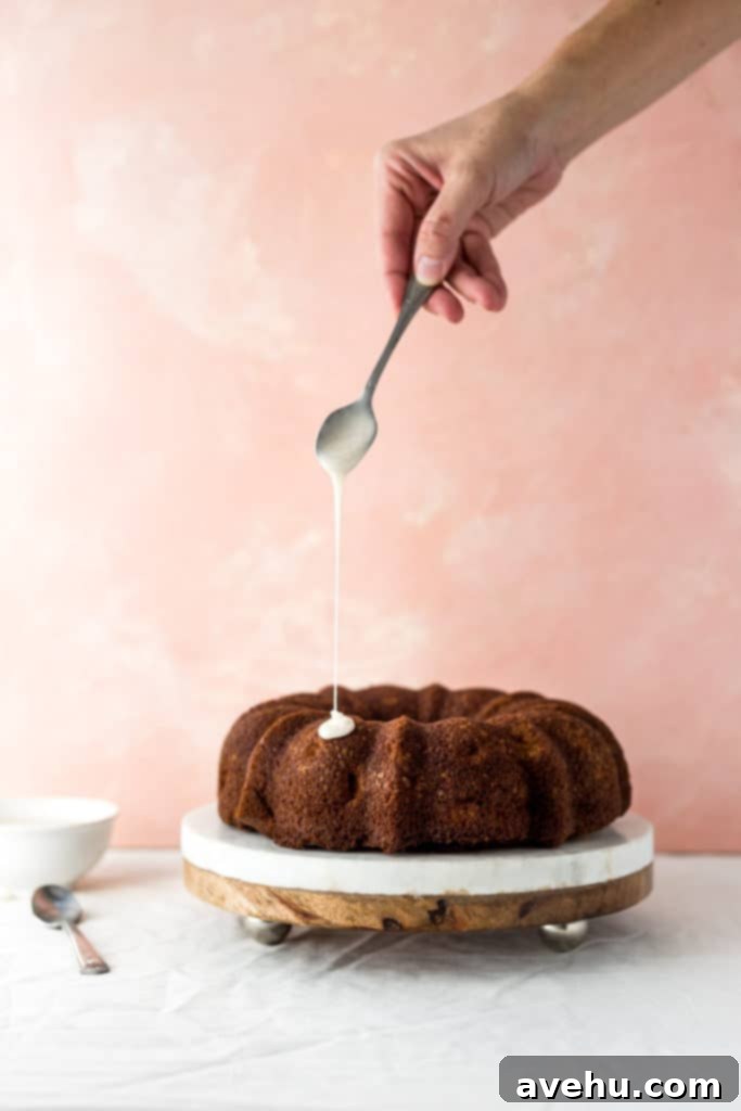 Spiced Honey-Glazed Apple Bundt Cake 2 A beautifully baked apple bundt cake on a marble cake stand, ready for glazing.