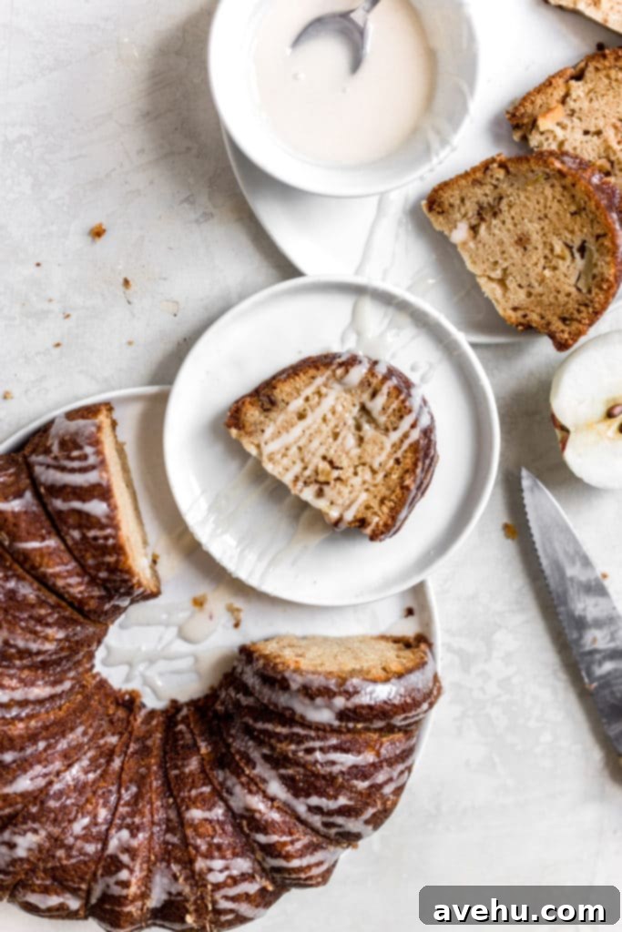 Spiced Honey-Glazed Apple Bundt Cake 4 A slice of a bundt cake on a small plate, surrounded by more plates and a whole sliced cake.