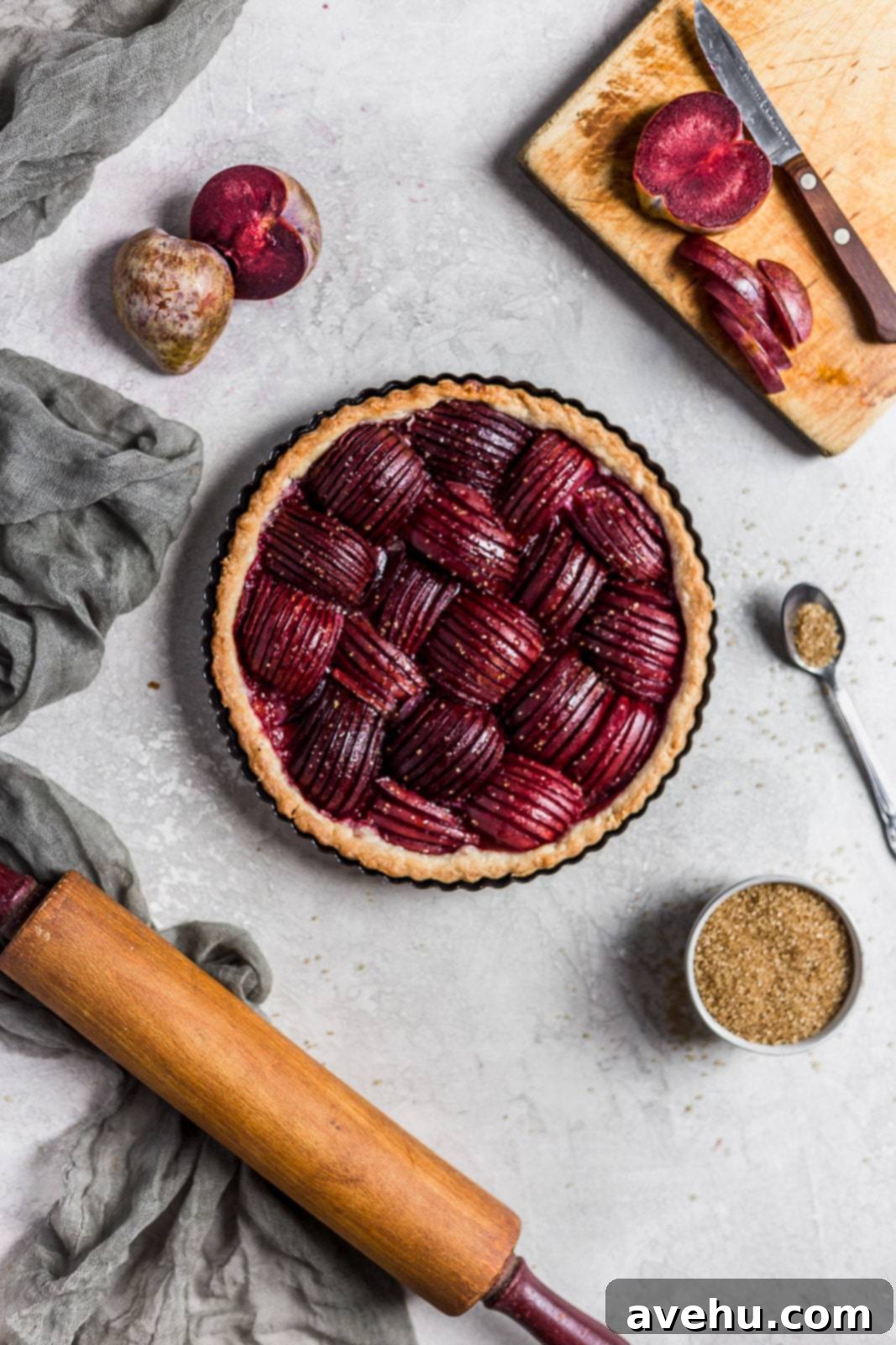 Effortlessly Elegant Plum Tart 2 Thinly sliced ripe plums artfully arranged in a golden pie crust, ready for baking.