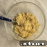 Chocolate Banana Velvet Dream 4 Mashed overripe bananas in a glass bowl on a tan linen, showing the desired lumpy texture.