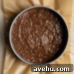 Chocolate Banana Velvet Dream 7 Chocolate banana cake batter in a springform pan lined with parchment paper, smoothed out and ready for baking.