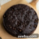 Chocolate Banana Velvet Dream 8 Baked chocolate banana cake resting on brown parchment paper, showcasing its golden-brown crust and perfectly suspended chocolate chips.