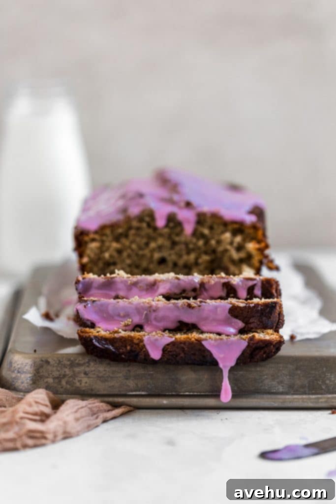 Nut-Free Banana Bread 5 Front view of sliced no nut banana bread with a vibrant purple grape glaze, showcasing the moist texture.