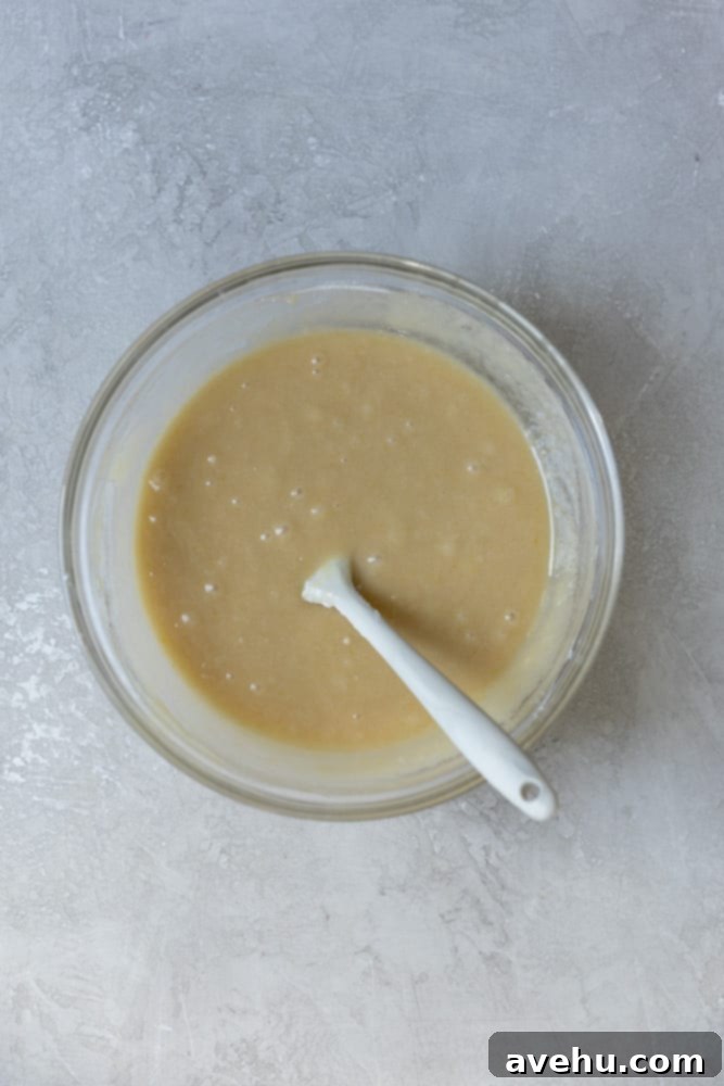 Irresistible Gooey One Bowl Blondie Cookies 3 Thick blondie batter in a glass bowl after dry ingredients have been folded in, showing a smooth consistency.