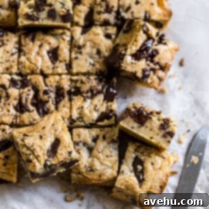 Irresistible Gooey One Bowl Blondie Cookies 6 Close-up of golden chocolate chip blondies with a perfect crinkled top, cut into squares and stacked.