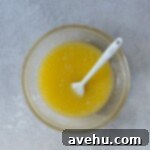 Irresistible Gooey One Bowl Blondie Cookies 7 Melted butter, sugar, and eggs mixed in a glass bowl.