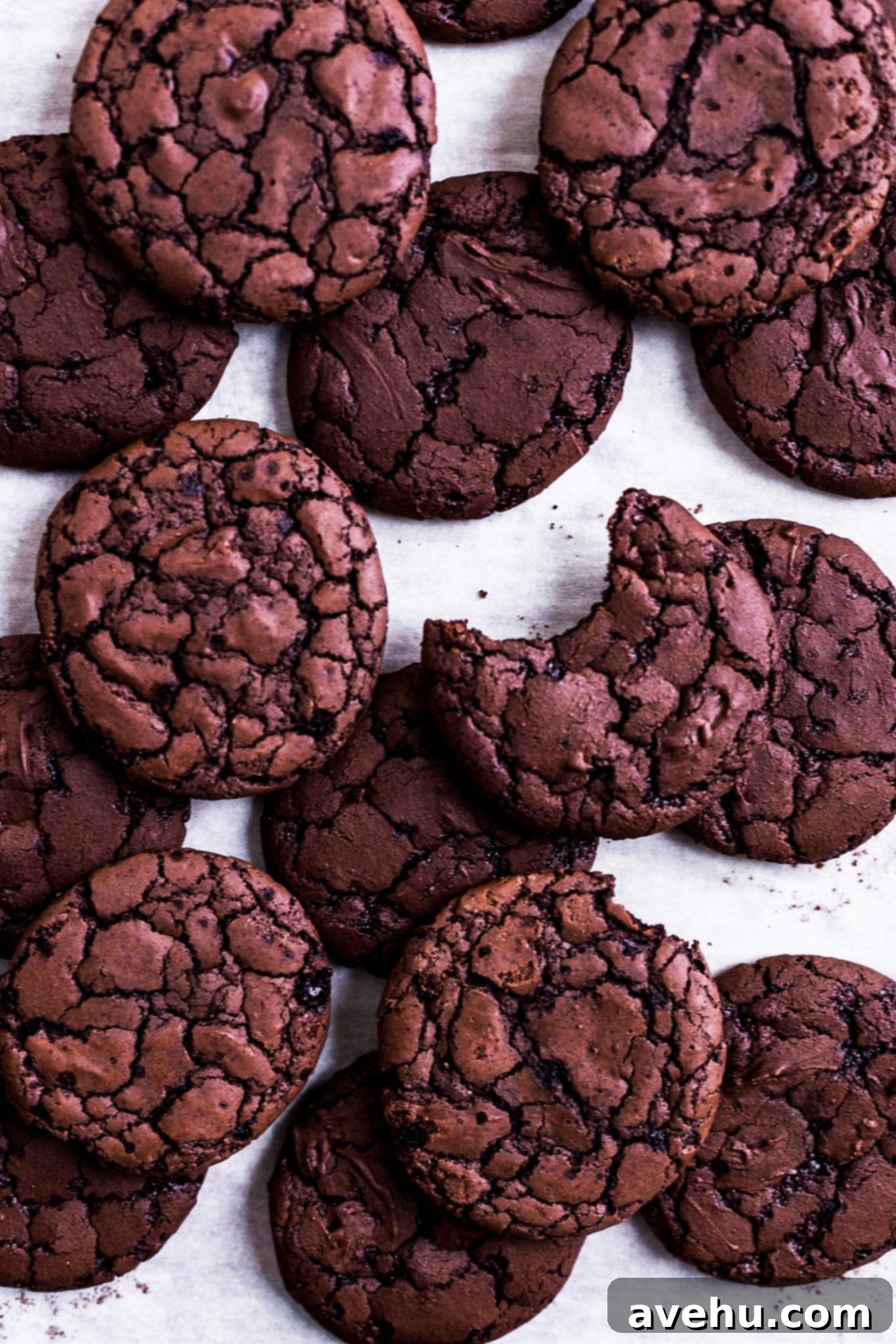 Brownie Cookie Blitz 2 Delicious chocolate brownie cookies with shiny, crinkly tops, arranged on parchment paper.