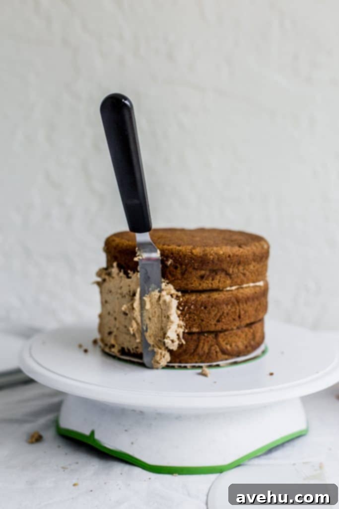 Mastering Two-Tier Cakes: Baking and Stacking Techniques 12 An offset spatula with frosting sticking to the side of a cake