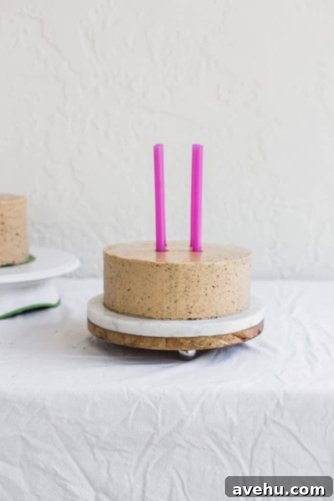 Mastering Two-Tier Cakes: Baking and Stacking Techniques 19 2 pink straws being inserted into the middle of a beige cake